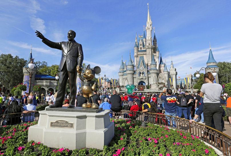 Goście oglądają przedstawienie w pobliżu pomnika Walta Disneya i Myszki Micky przed Zamkiem Kopciuszka w Magic Kingdom w Walt Disney World na Florydzie.