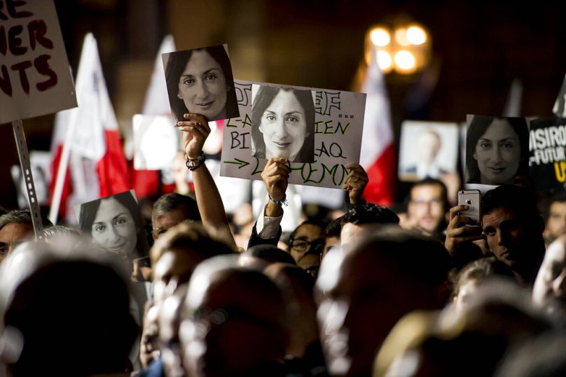 Protestujący trzymają zdjęcia podczas demonstracji przed biurem premiera Malty zorganizowanej przez grupy obywatelskie Occupy Justice i Republica w Valletcie, listopad 2019 r.