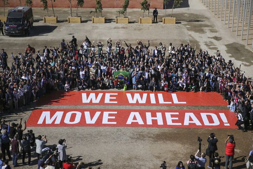 Uczestnicy konferencji klimatycznej COP22 pozują wspierając negocjacje klimatyczne i porozumienie paryskie, ostatniego dnia konferencji, Marrakesz, listopad 2016 r.