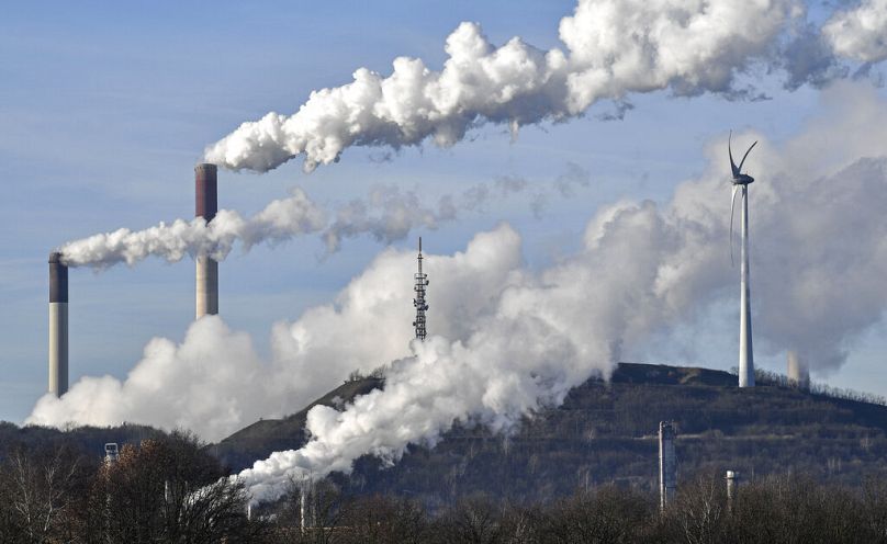 Elektrownia węglowa Uniper i para rafinerii BP obok generatora wiatrowego w Gelsenkirchen w Niemczech.