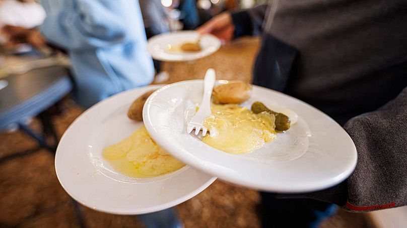 Kelner niesie raclette klientom zgromadzonym w Morgins na pierwszych Mistrzostwach Świata w Raclette.