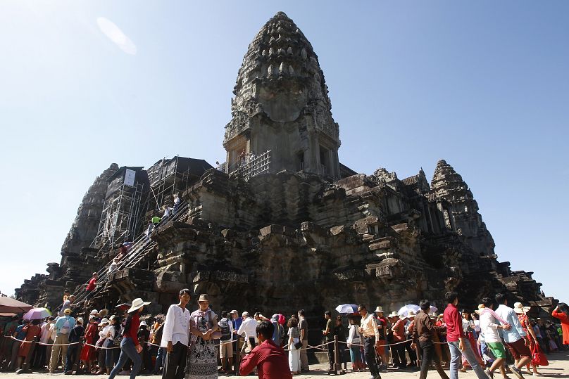 Turyści ustawiają się w kolejce, aby rozbudować świątynię Angkor Wat niedaleko Siem Reap w Kambodży.