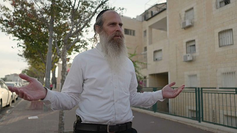 Izraelczyk na ulicy nosi boczne ramię.  Październik 2023