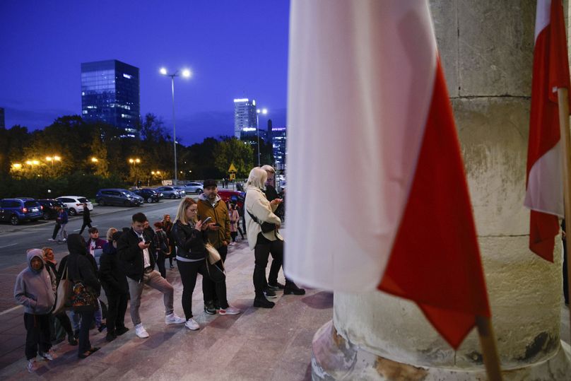 Ludzie czekają w kolejce do oddania głosu podczas wyborów parlamentarnych w Warszawie, październik 2023 r