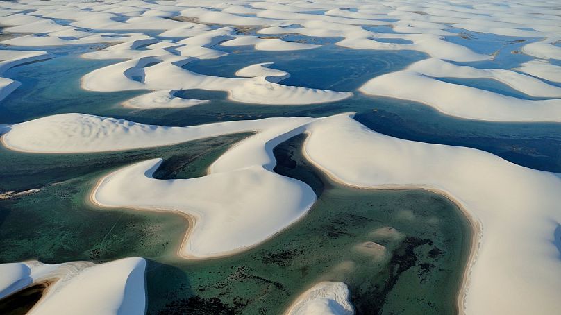 Nieziemski krajobraz Lençóis Maranhenses najlepiej podziwiać w lipcu, kiedy odwiedzający mogą pływać w błękitnych lagunach.