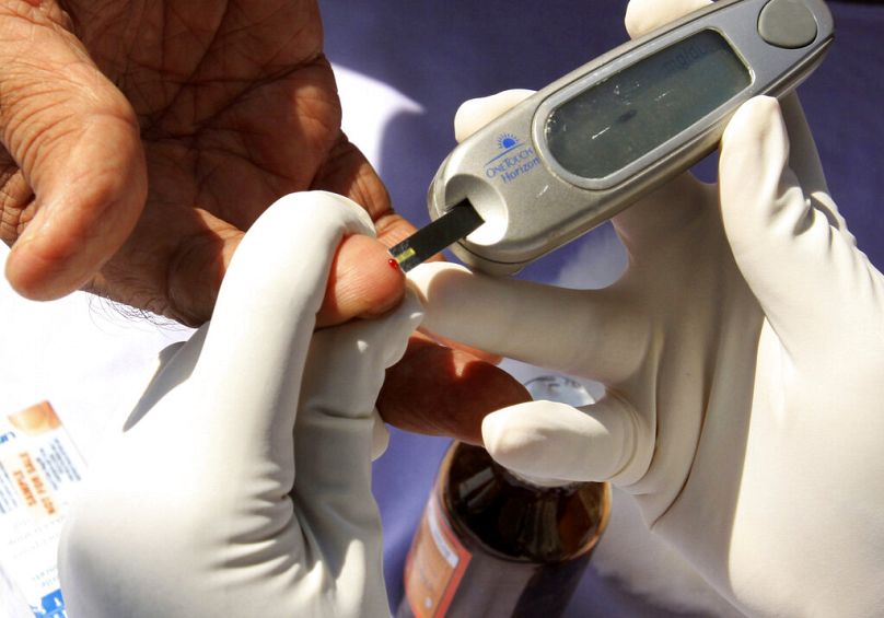 Pielęgniarka pobiera próbkę krwi od pacjenta podczas bezpłatnego obozu kontrolnego w kierunku cukrzycy w Hyderabad, listopad 2009
