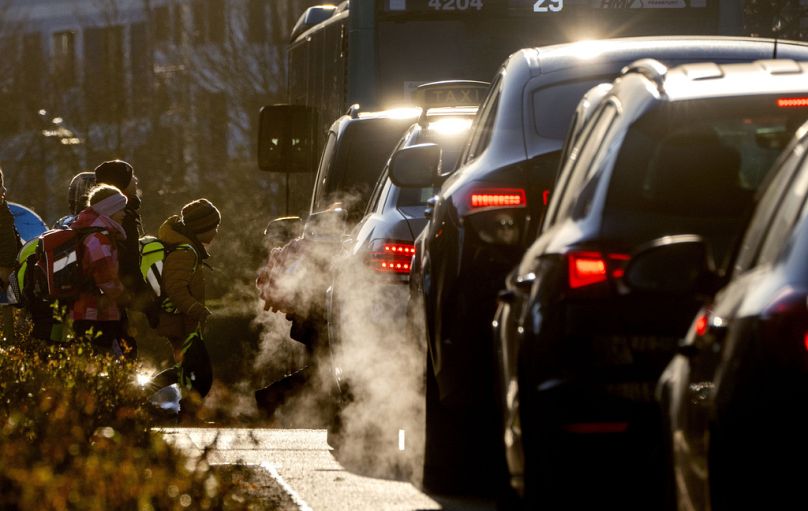 Samochody wydzielają spaliny, gdy dzieci udają się do szkoły we Frankfurcie, luty 2023 r
