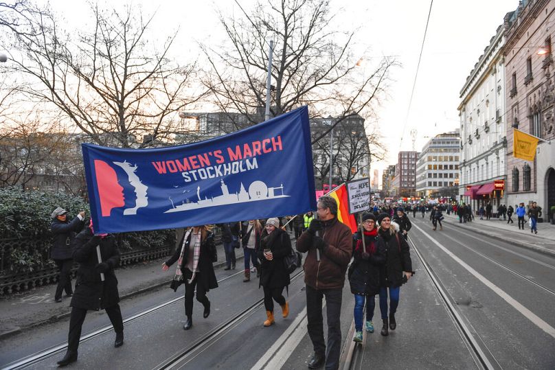 Protestujący niosący transparenty i plakaty biorą udział w Marszu Kobiet w Sztokholmie, Szwecja, sobota, 21 stycznia 2017 r.