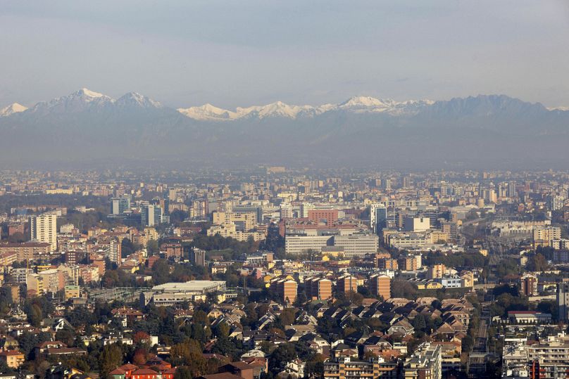 W tle widok na panoramę Mediolanu z przedalpami Lombardii.