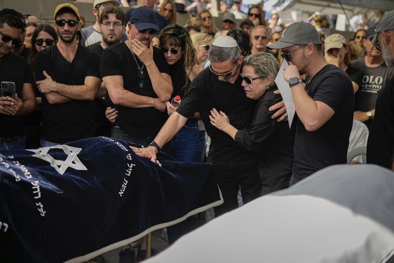 Żałobnicy gromadzą się w żałobie wokół ciał Danielle Waldmann i jej partnera Noama Shai podczas ich pogrzebu w mieście Kiryat Tivon w północnym Izraelu, 12 października 2023 r.