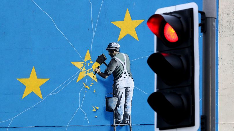 Widok na mural Banksy'ego dotyczący Brexitu, przedstawiający mężczyznę odrywającego flagę UE w Dover w Anglii