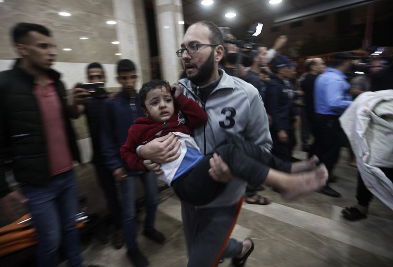 Ranne palestyńskie dziecko zostaje przeniesione do szpitala Nasser po izraelskim bombardowaniu obozu dla uchodźców Khan Younis w południowej Strefie Gazy, wtorek, 21 listopada 2023 r.