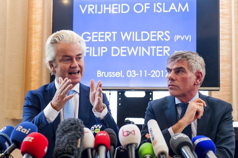PLIK: Holenderski przywódca skrajnej prawicy Geert Wilders (po lewej) i belgijski polityk antyimigrancki Filip Dewinter rozmawiają w holenderskim parlamencie, listopad 2017 r.