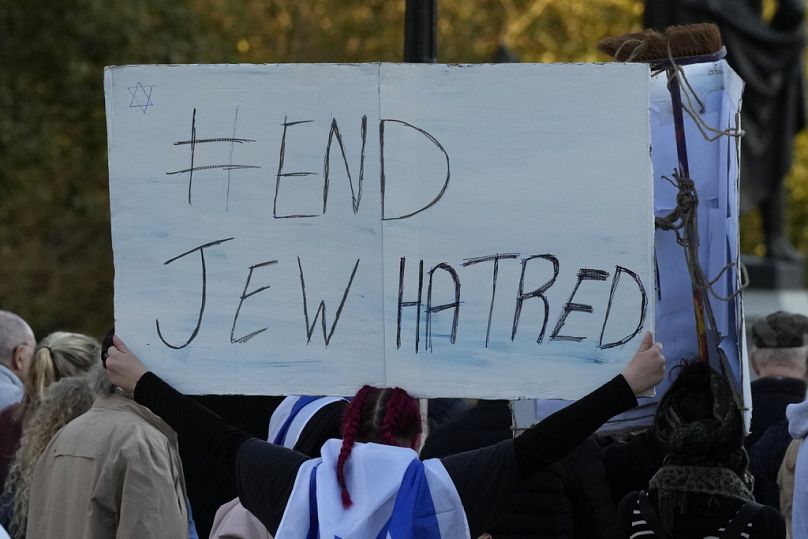 Izraelska zwolenniczka trzyma plakat z napisem „Koniec nienawiści do Żydów”, gdy bierze udział w protestach w Londynie w zeszłym miesiącu