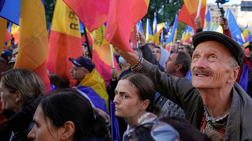 Ludzie machają flagami podczas antyrządowego protestu zorganizowanego przez skrajnie prawicowy Sojusz na rzecz Jedności Rumunów (AUR) w Bukareszcie, Rumunia, sobota, 2 października 2021 r.