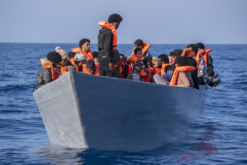 Migranci z Erytrei, Libii i Sudanu tłoczą się na pokładzie drewnianej łodzi na Morzu Śródziemnym, około 50 mil na północ od Libii, czerwiec 2023 r.