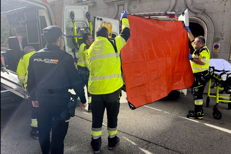 Sanitariusze zasłaniają widok na ambulans zaparkowany na miejscu strzelaniny w Madrycie, czwartek, 9 listopada 2023 r.