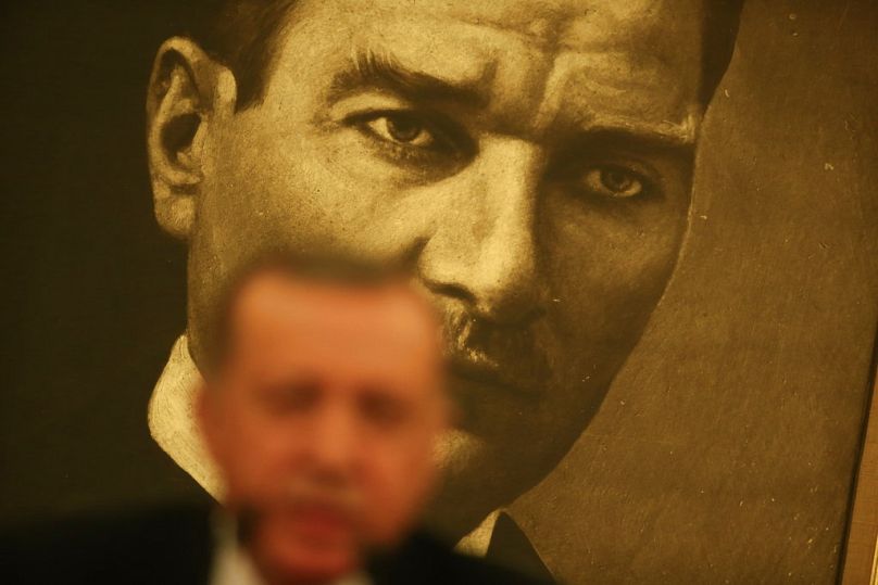 Na tle plakatu przedstawiającego Mustafę Kemala Ataturka, założyciela współczesnej Turcji, prezydent Turcji Recep Tayyip Erdogan rozmawia z przedstawicielami mediów w Stambule, kwiecień 2017 r.
