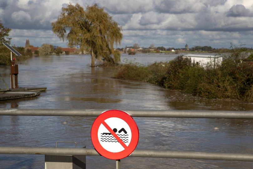 Ten ogólny widok z mostu ze znakiem zakazu pływania przedstawia pola zalane przez powodzie w Poperinge we Flandrii Zachodniej, 11 listopada 2023 r.