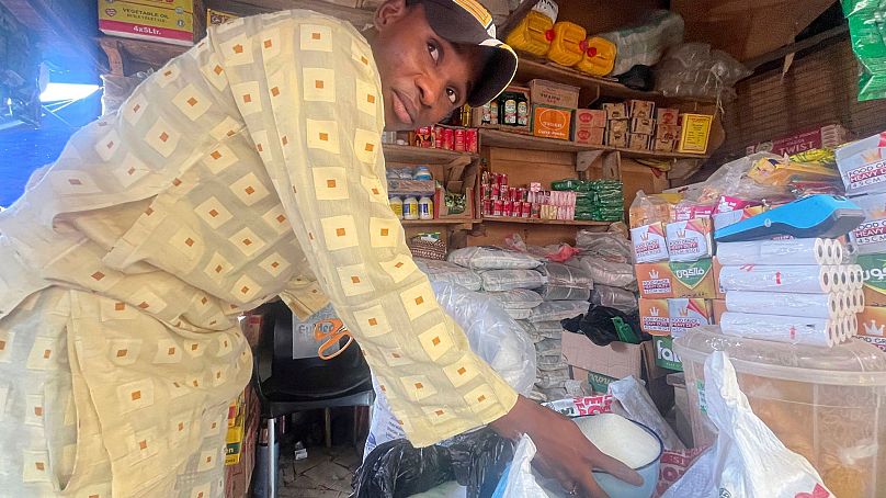 Abba Usman sprzedaje cukier granulowany w swoim sklepie na rynku w Abudży, Nigeria, 27 października 2023 r.