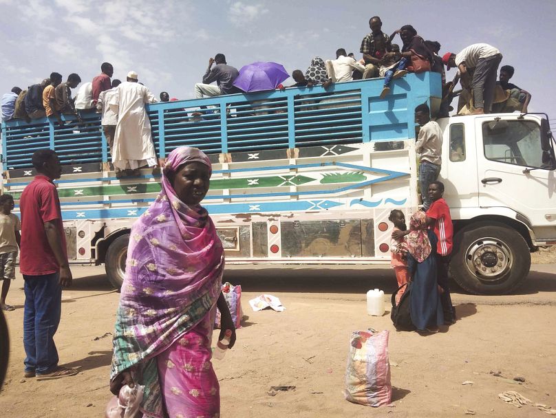 Ludzie wsiadają do ciężarówki wyjeżdżającej z Chartumu, czerwiec 2023 r