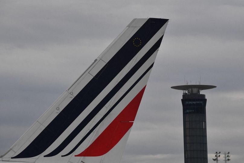 Ogon samolotu Air France i wieża kontroli ruchu lotniczego na lotnisku Roissy-Charles de Gaulle.