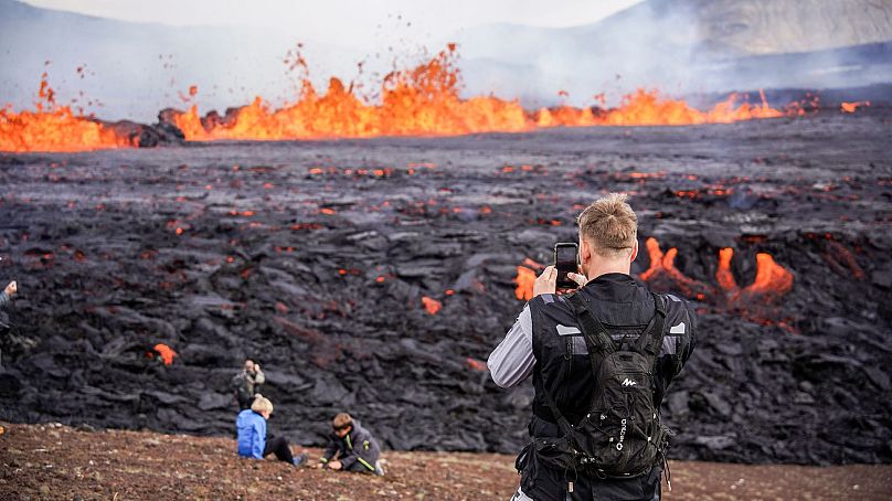 Ludzie patrzą na lawę wypływającą z wulkanu Fagradalsfjall na Islandii, 3 sierpnia 2022 r.