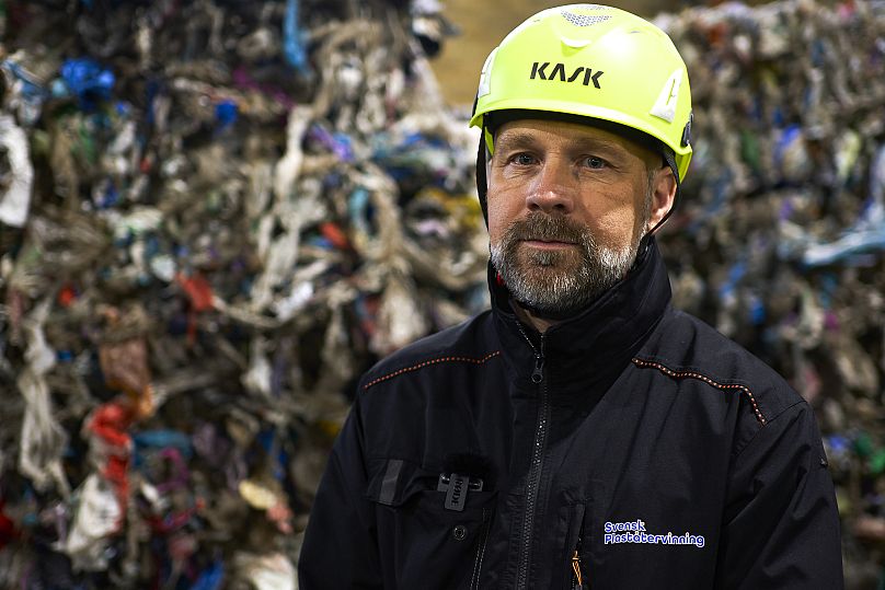 Mattias Philipsson, dyrektor generalny szwedzkiego działu recyklingu tworzyw sztucznych pozuje przed odpadami z tworzyw sztucznych przechowywanymi w nowej sortowni odpadów z tworzyw sztucznych w Motala w środkowej Szwecji.