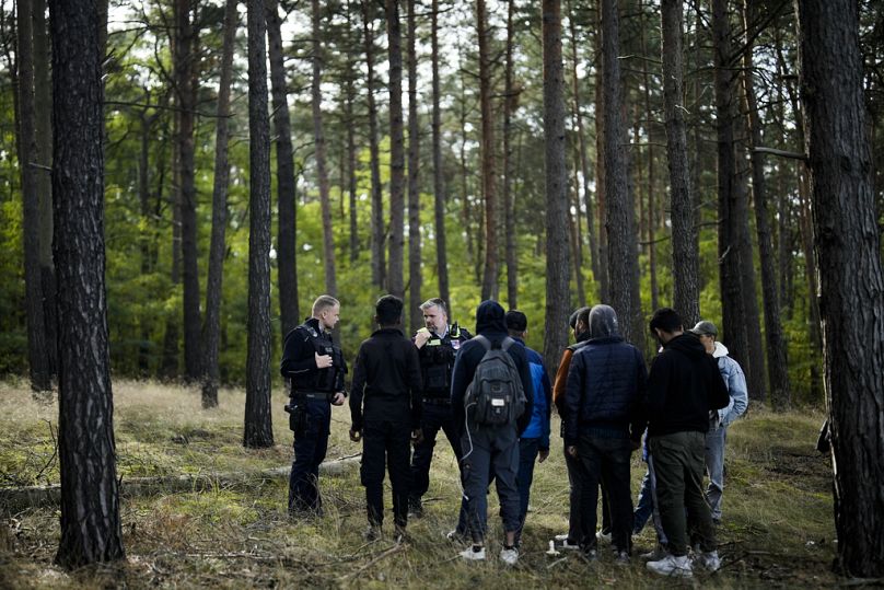 Funkcjonariusz Policji Federalnej przemawia przez radio, gdy wraz ze swoim kolegą tropi grupę migrantów, którzy nielegalnie przekroczyli granicę z Polski do Niemiec.