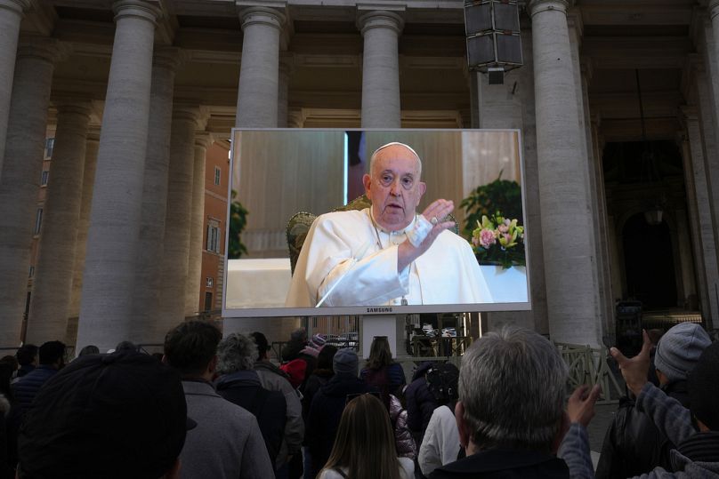 Na ogromnym ekranie widać, jak papież Franciszek udziela błogosławieństwa podczas południowej modlitwy Anioł Pański z kaplicy hotelu na terenie Watykanu, gdzie mieszka, w niedzielę, 11 listopada br.