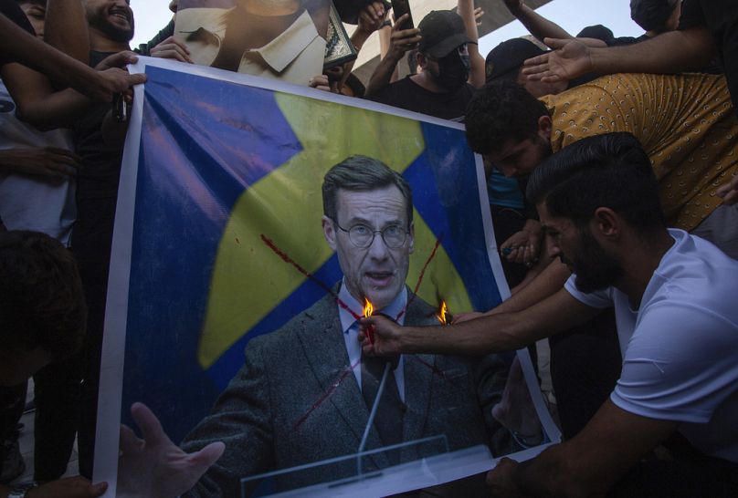 Irakijczycy palą zdjęcie premiera Szwecji Ulfa Kristerssona podczas protestu na placu Tahrir.