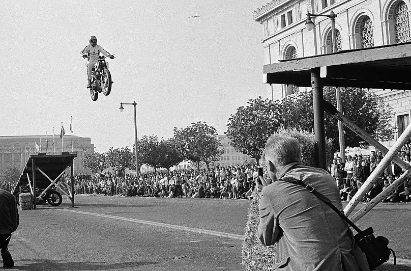 Evel Knievel przeskakuje rower między dwiema rampami oddalonymi od siebie o trzydzieści metrów, aby otworzyć wystawę rowerów sportowych w Civic Center, 23 listopada 1967, San Francisco