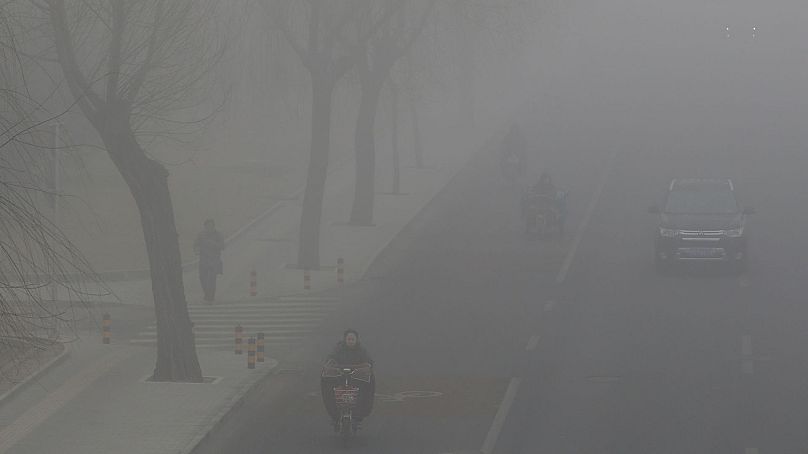 Ludzie jeżdżą i jeżdżą wśród smogu w Pekinie, Chiny, 14 lutego 2017 r.