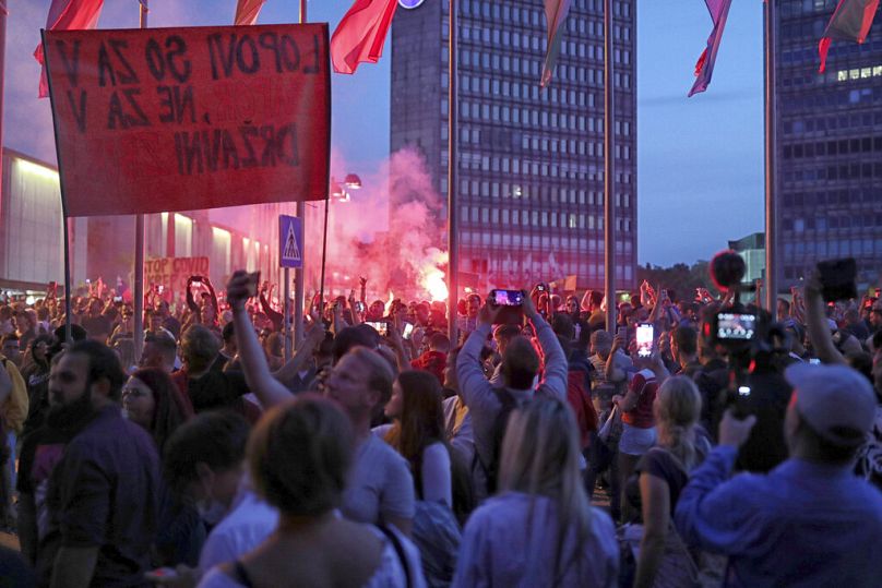 Protestujący przeciwko szczepionkom zbierają się w pobliżu parlamentu w Lublanie w Słowenii, środa, 15 września 2021 r.