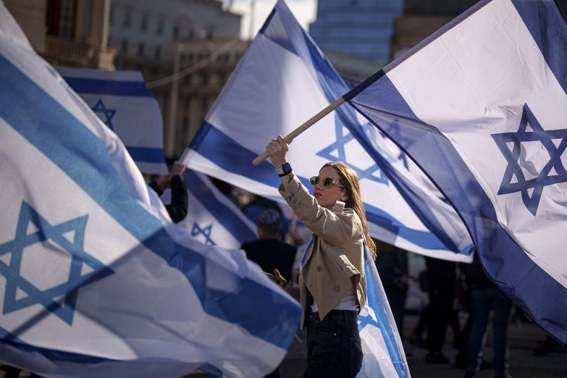 PLIK – Kobieta trzyma izraelską flagę podczas wiecu w wyrazie solidarności z Izraelem i osobami przetrzymywanymi jako zakładnicy przez Hamas w Gazie w Bukareszcie, Rumunia, 12 listopada 2023 r.