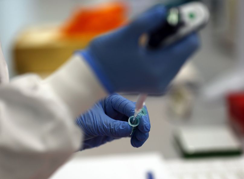 Asystent laboratoryjny używa pipety do przygotowania RNA wirusa koronowego do sekwencjonowania w Wellcome Sanger Institute w Cambridge, 2021.