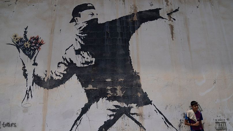 Mural autorstwa tajemniczego brytyjskiego artysty graffiti Banksy'ego na stacji benzynowej w Betlejem na Zachodnim Brzegu