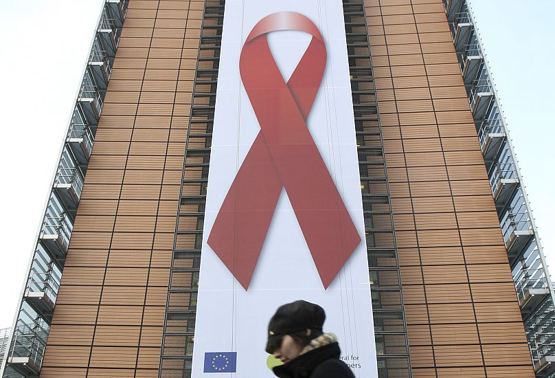 Gigantyczny baner z czerwoną wstążką informującą o AIDS został wywieszony podczas Światowego Dnia AIDS w budynku Komisji Europejskiej w Brukseli w 2009 r.