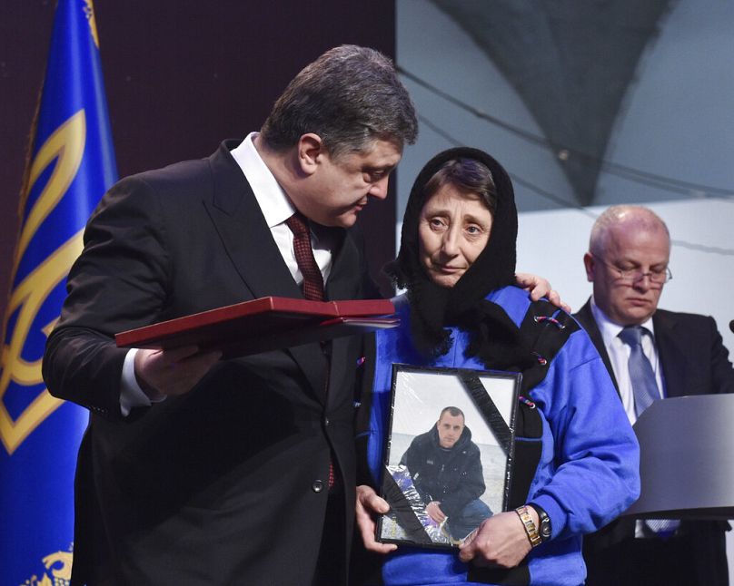 Prezydent Ukrainy Poroszenko wręcza nagrodę Bohatera Ukrainy krewnemu działacza zabitego podczas masowych protestów podczas ceremonii w Kijowie, 20 lutego 2015 r.