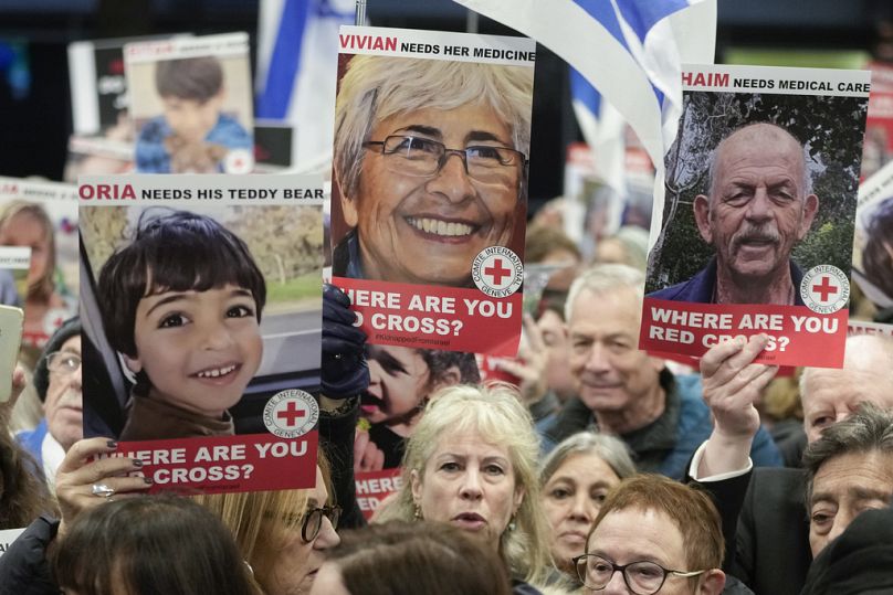 Osoba trzyma plakat przedstawiający zmarłą Vivian Silver, gdy pracownicy służby zdrowia biorą udział w demonstracji przed Międzynarodowym Komitetem Czerwonego Krzyża w Londynie