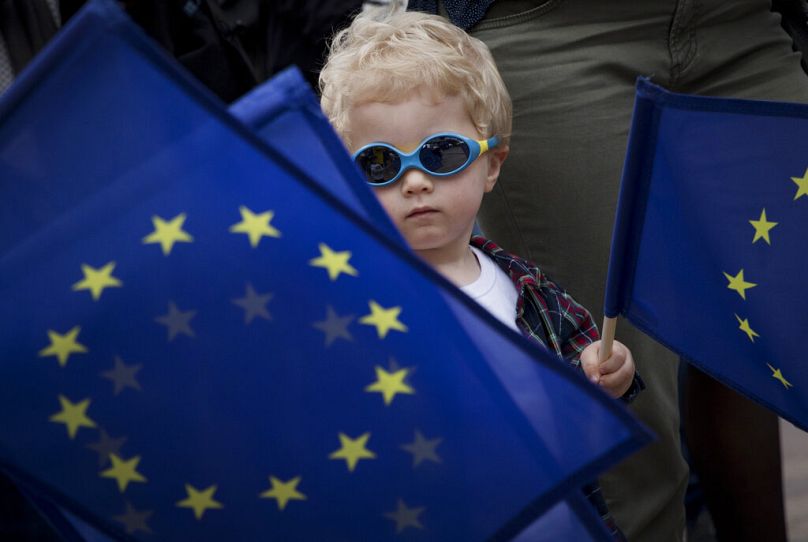 młodzi chłopcy machają flagą UE podczas festiwalu przed Parlamentem Europejskim w Brukseli, maj 2019 r