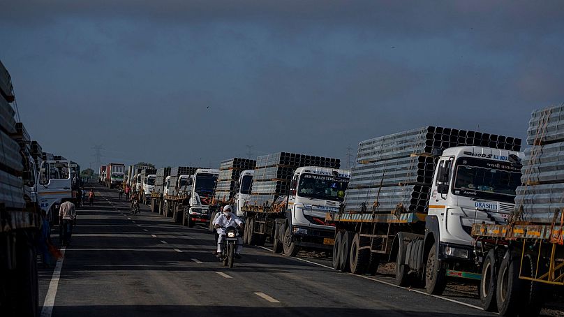 Ciężarówki przewożą ramy ze stopu aluminium do parku energii odnawialnej firmy Adani Green Energy Limited w pobliżu Khavda w Indiach, 21 września 2023 r.