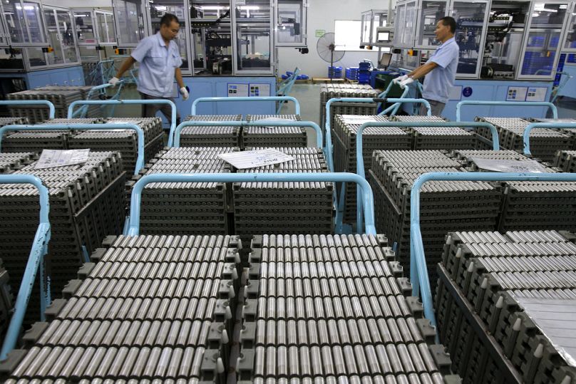 Pracownicy przenoszą akumulatory litowo-jonowe w fabryce w Taizhou w prowincji Jiangsu we wschodnich Chinach, lipiec 2018 r.