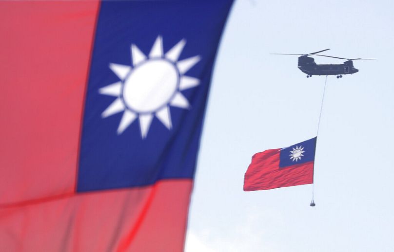 Helikoptery przelatują nad Kancelarią Prezydenta z flagą narodową Tajwanu podczas obchodów Święta Narodowego przed budynkiem Prezydenckim w Tajpej, październik 2021 r.