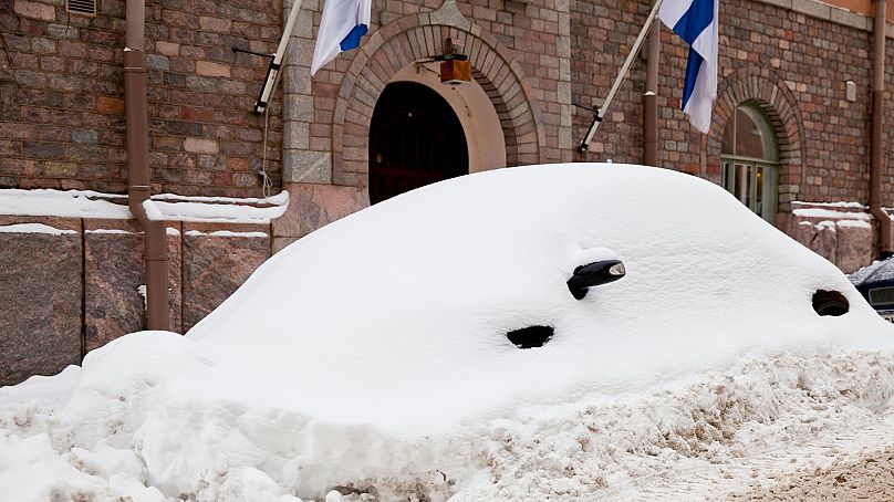 Samochód pokryty śniegiem w Helsinkach zimą.