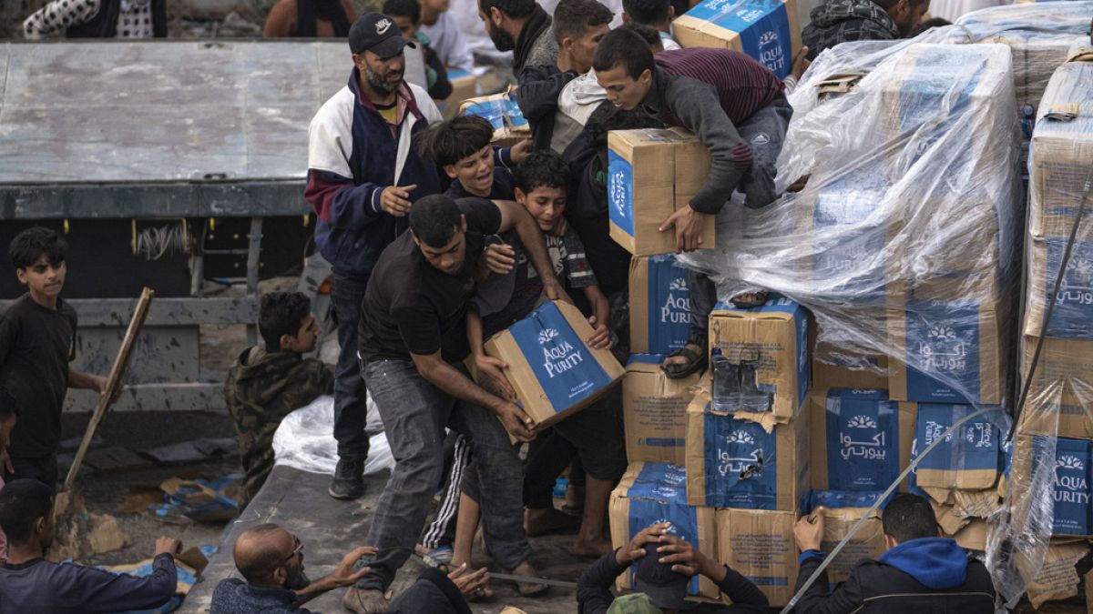 Palestinians loot a humanitarian aid truck as it crossed into the Gaza Strip in Rafah, Sunday, Dec. 17, 2023.