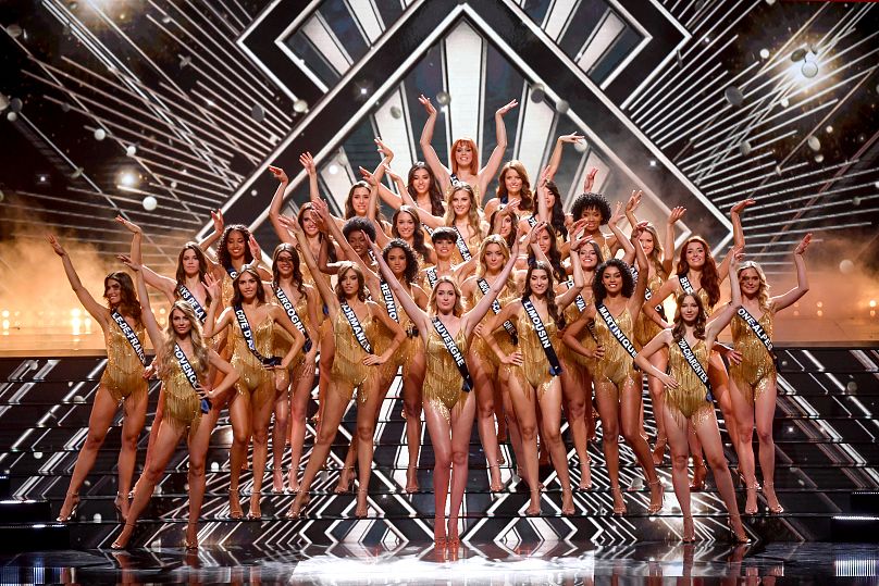 Uczestniczki wyborów Miss France 2024 pozują na scenie.