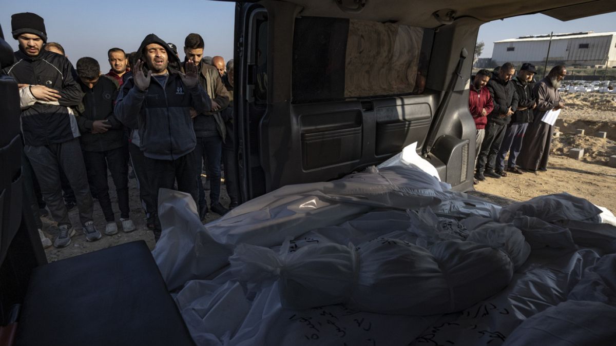 Palestinians pray during the funeral of their relatives killed in the Israeli bombardment of the Gaza Strip, at a cemetery in Rafah, southern Gaza, Tuesday, Dec. 19, 2023.