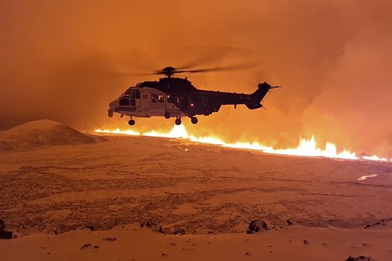 To zdjęcie wykonane z filmu dostarczonego przez islandzką straż przybrzeżną przedstawia helikopter lecący w pobliżu magmy płynącej po wzgórzu w pobliżu Grindavik na islandzkim półwyspie Reykjanes.