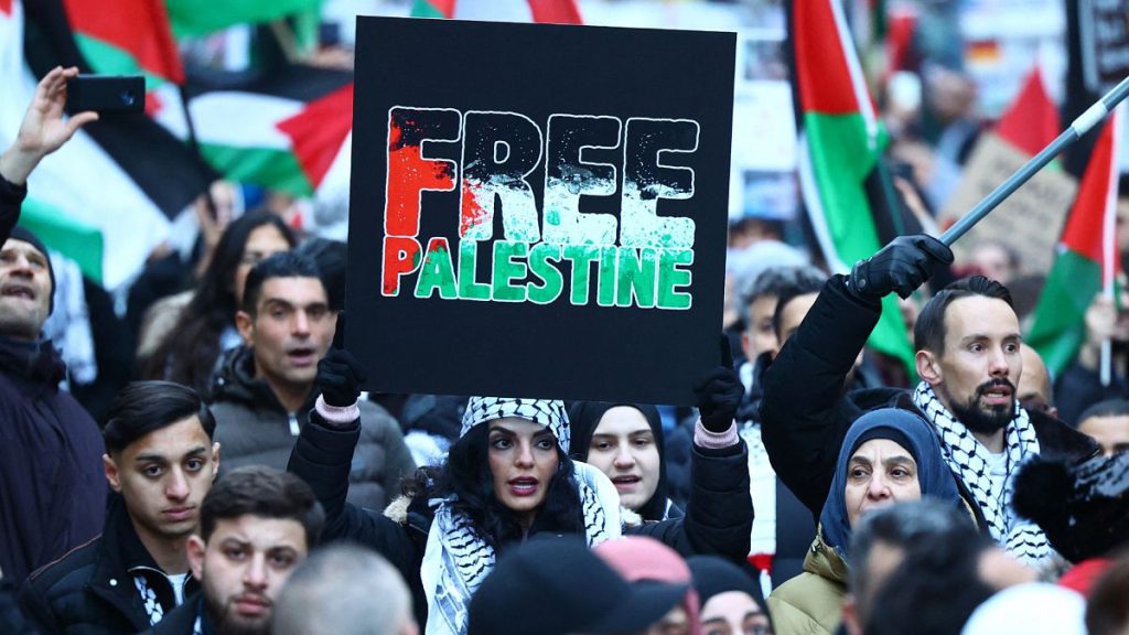 A demonstrator holds up a sign reading